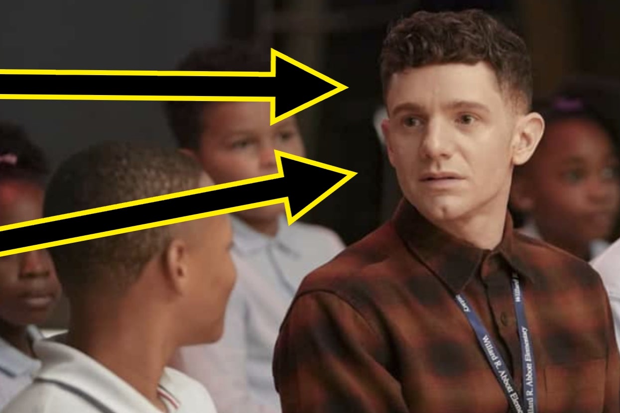 Person in a plaid shirt looking at a person sitting nearby. Large yellow arrows point toward them, suggesting attention or focus