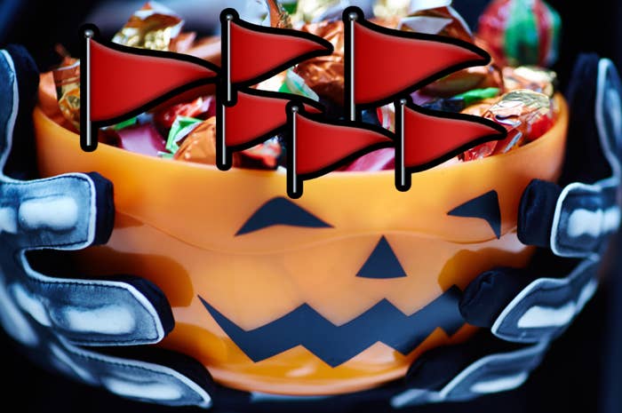 Skeleton hands holding a pumpkin-shaped vessel  filled with candy, surrounded by reddish  flags
