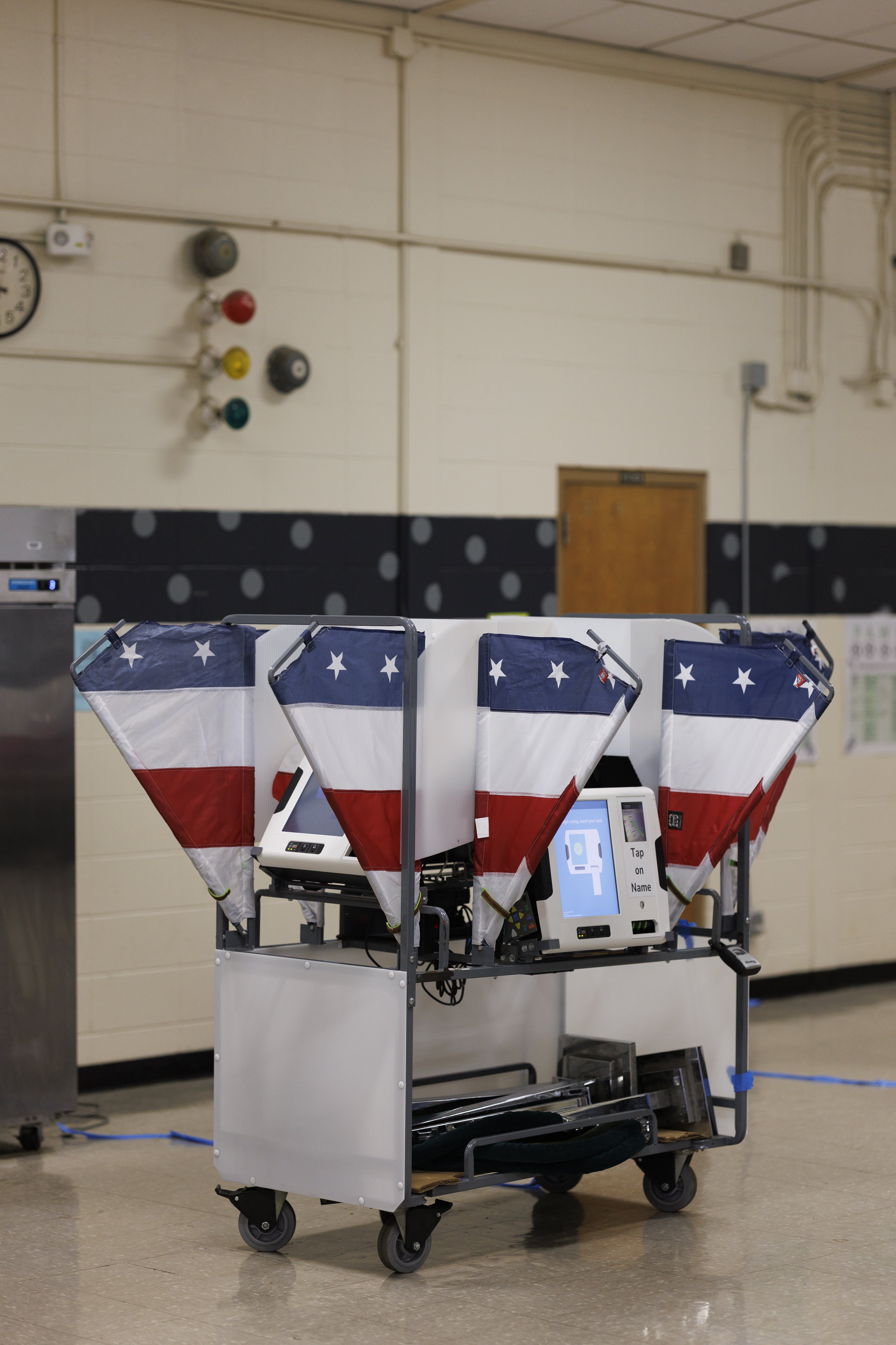 Voting machines in a polling station, each machine adorned with star-spangled decor resembling the U.S. flag