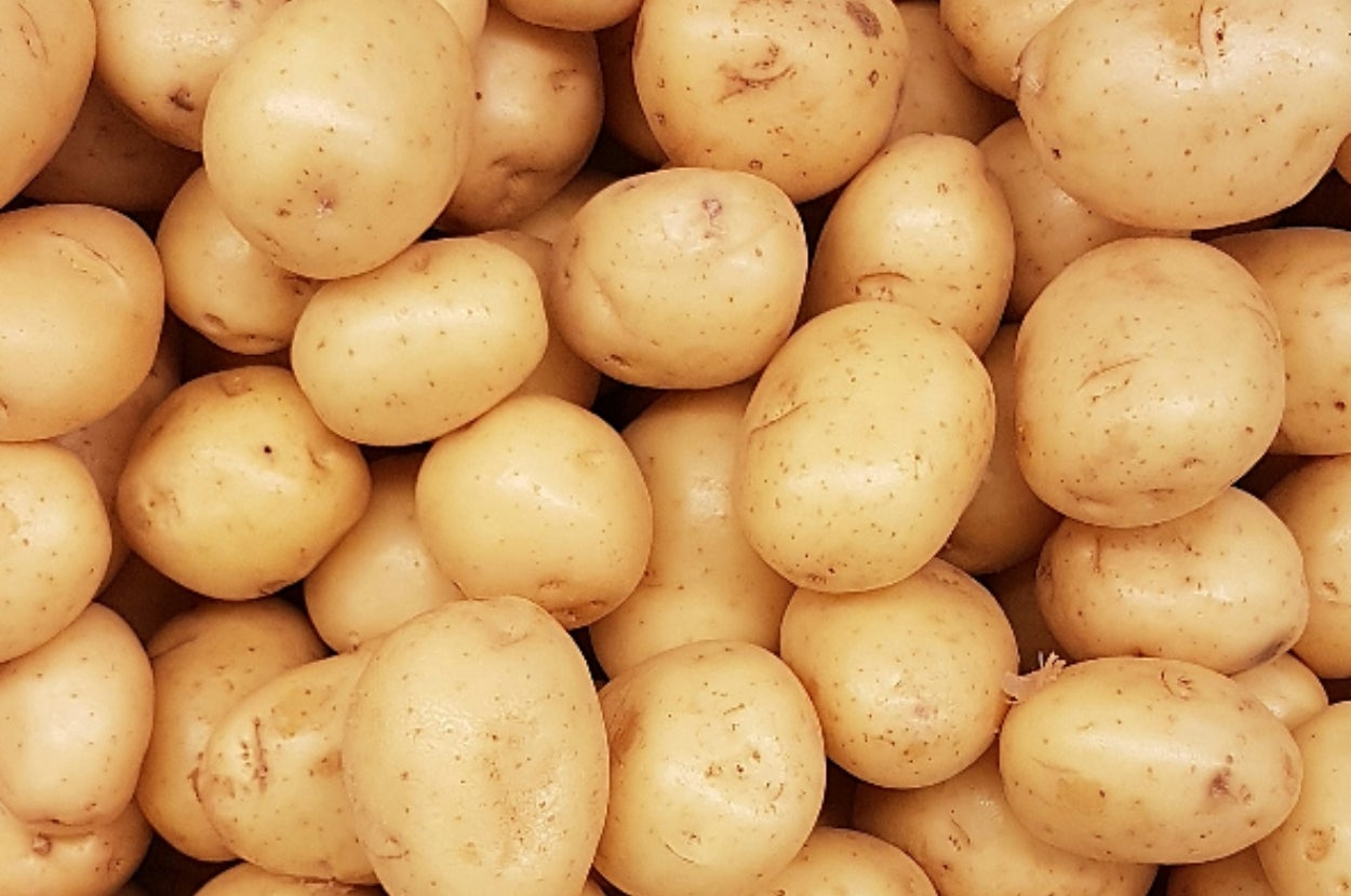 A pile of fresh potatoes with smooth skins, closely stacked together