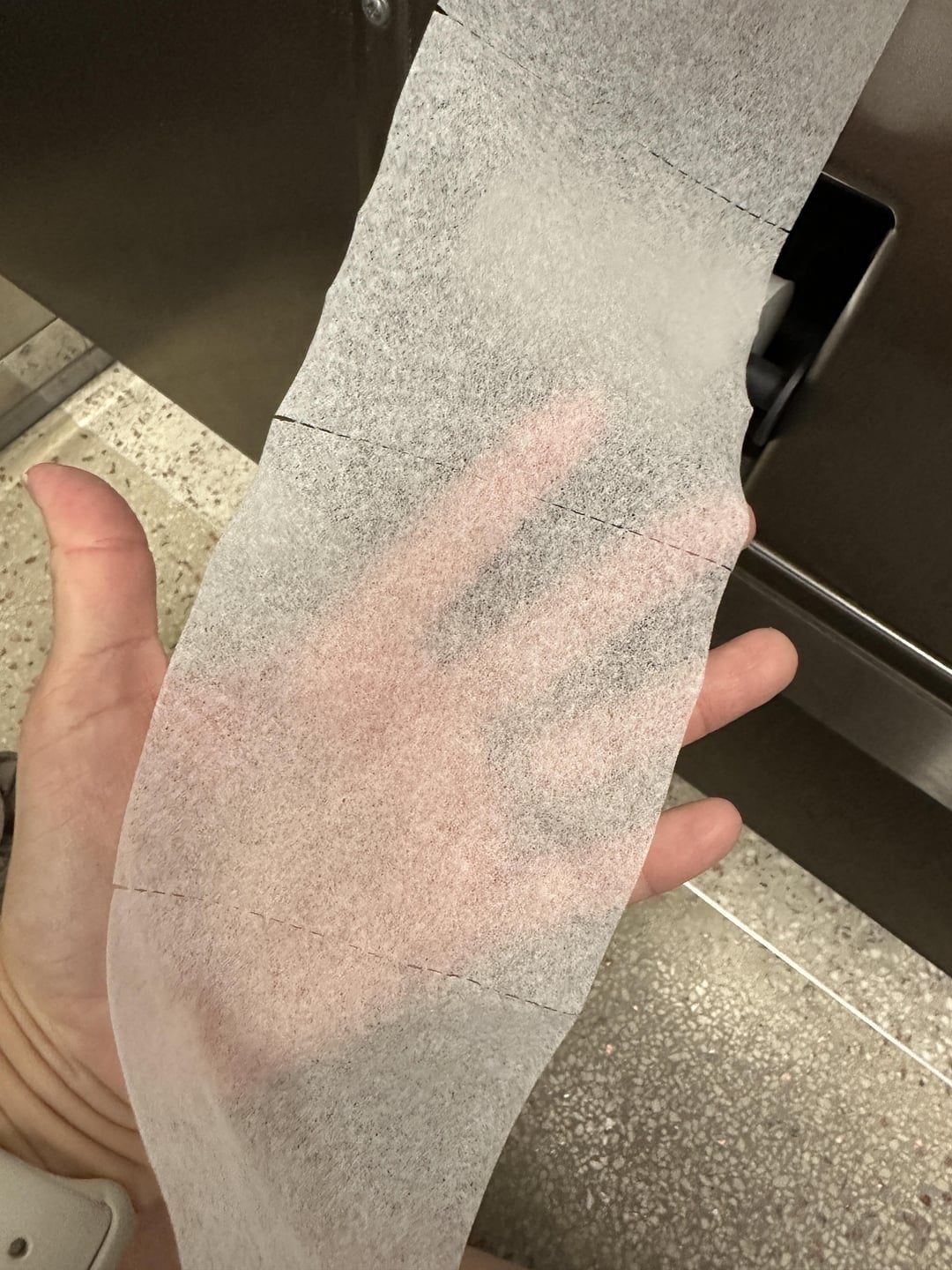A manus  holding a azygous  bladed  expanse  of toilet spot   screen  insubstantial  successful  a restroom