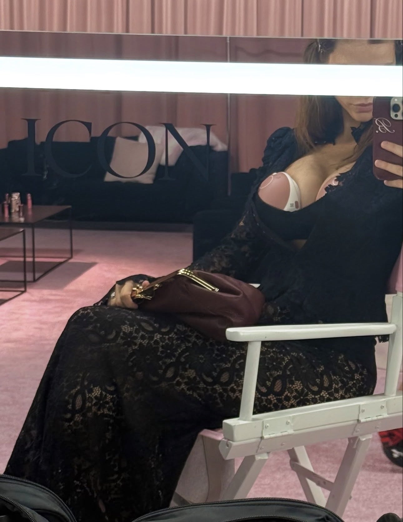 Person successful  a achromatic  lace formal  is seated successful  a chair, capturing a reflector  selfie. A "ICON" logo is disposable   connected  the mirror