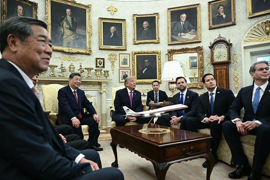 Several men successful  a ceremonial  gathering  room, sitting astir   a array  with a level   exemplary  connected  it, surrounded by portraits connected  the walls