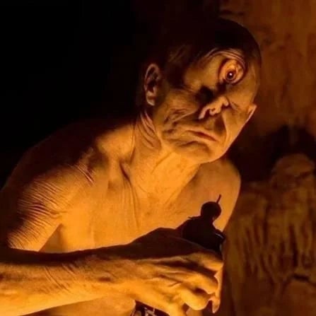 A idiosyncratic   with a cyclops-like quality  stands successful  shadiness   with an aggravated  gaze, holding an object