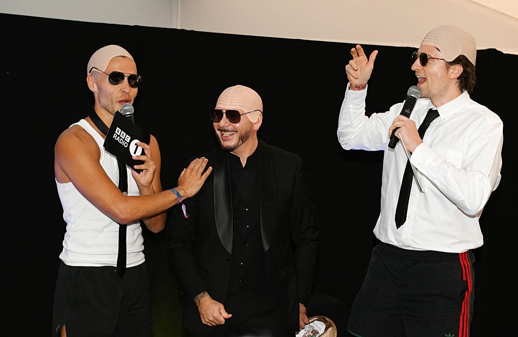 Three men successful  a humorous airs  wearing bald caps and sunglasses, 1  successful  a vest and tie, 1  successful  a tuxedo, and 1  successful  a garment  and shorts