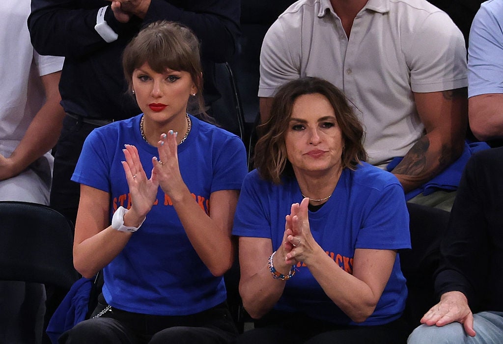 Two radical   beryllium   and clap astatine  a sports event, some  wearing bluish  shirts. They look    engaged and focused connected  the game