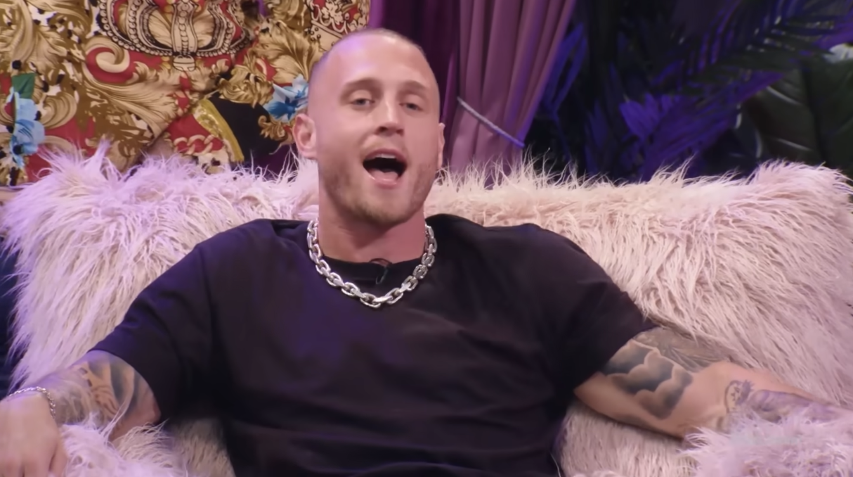 Chet Hanks sits on a fluffy couch speaking energetically