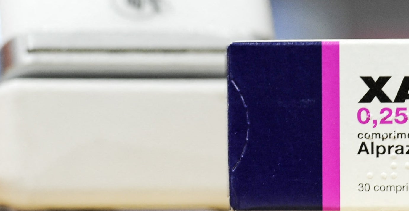Box of Xanax 0.25 mg tablets on a wooden counter near an electronic device