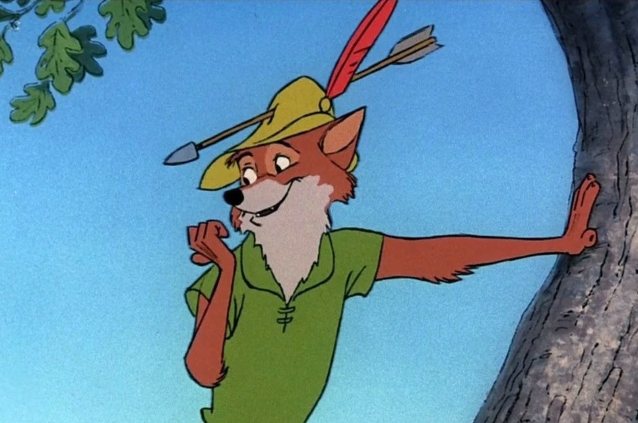 Animated fox dressed as Robin Hood, wearing a hat with a feather, leaning against a tree and smiling