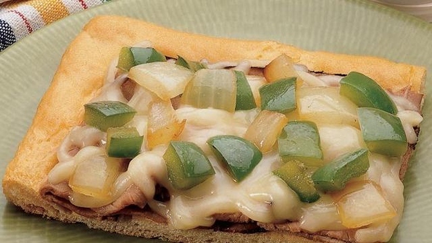 What do I need to make it?1 can (8 oz) Pillsbury® refrigerated crescent dinner rolls or 1 can (8 oz) Pillsbury® Crescent Recipe Creations® refrigerated seamless dough sheet8oz thinly sliced cooked roast beef (from deli)1 tablespoon Italian dressing1 to 1 1/2 cups shredded mozzarella cheese (4 to 6 oz)2 tablespoons olive or vegetable oil1 cup coarsely chopped green bell pepper1 cup coarsely chopped onions1/2 teaspoon beef-flavor instant bouillon How do I make it?1. Heat oven to 375°F. 2. If using crescent rolls: Unroll dough in ungreased 13x9-inch pan. Press in bottom and 1/2 inch up sides. Firmly press perforations to seal. If using dough sheet: Unroll dough in ungreased 13x9-inch pan. Press in bottom and 1/2 inch up sides. 3. Wrap beef tightly in foil. Place dough and beef in oven. 4. Bake about 10 minutes or until crust is light golden brown. Arrange warm beef over partially baked crust. Brush with dressing. Sprinkle with cheese. 5. Bake 8 to 10 minutes longer or until edges of crust are golden brown and cheese is melted. Meanwhile, in 8-inch skillet, heat oil over medium heat until hot. Add bell pepper, onions and bouillon; cook and stir 3 to 5 minutes or until tender. Spoon cooked vegetables over melted cheese.