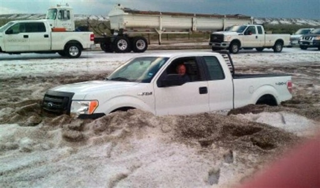 In this Wednesday, April 11, 2012 photo provided by the Amarillo/Potter/Randall Office of Emergency Management a motorist sits in a truck partially buried in slushy hail near Amarillo, Texas.