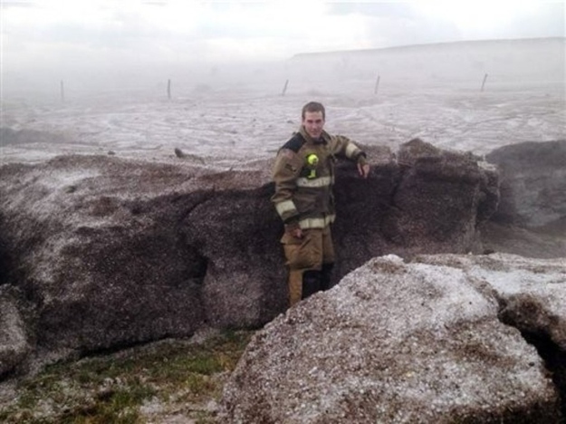 In this photo provided by the Amarillo/Potter/Randall Office of Emergency Management shows Potter County firefighter Matt Dryden standing next to a wall of hail Wednesday, April 11, 2012 in near Amarillo, Texas. National Weather Service Meteorologist Justyn Jackson said Thursday that hail that fell amid a rainstorm the day before was real small but there was a lot of it in a concentrated area, accumulating 2- to 4-feet deep.