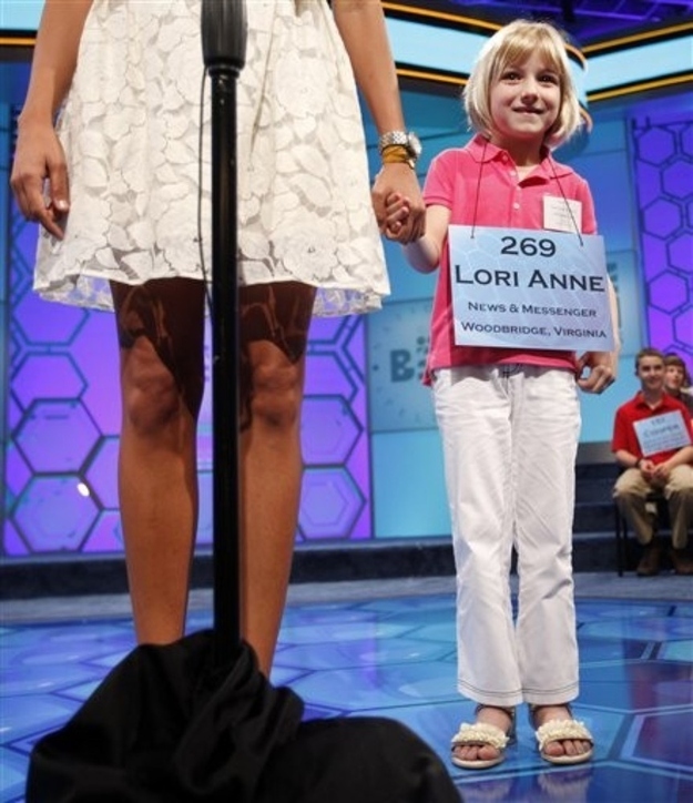 Lori Anne Madison, 6, of Woodbridge, Va., right, the youngest speller in the National Spelling Bee, joins Samantha Steele, with ESPN, at the microphone, during the National Spelling Bee in Oxon Hill, Md., Wednesday, May 30, 2012.