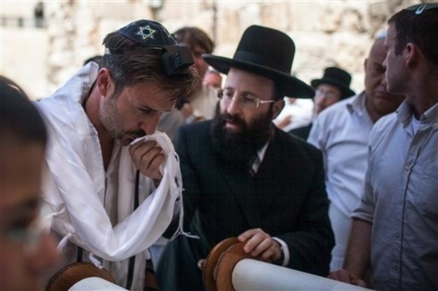 In this Handout photo released by the Israeli Tourism Ministry, actor David Arquette, left, celebrates his "Bar Mitzvah" at the Western Wall, the holiest site where Jews can pray, in Jerusalem's Old City, Monday, June 11, 2012. The 40-year-old, Arquette, "Scream" star came to shoot a segment for his travel show, ended up having a Bar Mitzvah too and completed the Jewish rite of passage Monday in Jerusalem. Arquette, who has been elusive during his visit, later posted on his Twitter account: "I had my Bar Mitzvah today at the wall. Finally I'm a man."