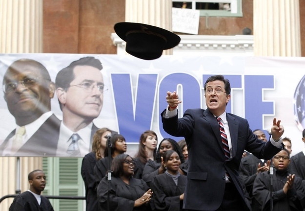 Actor and television host Stephen Colbert throws a hat into the crowd which belonged to former Republican Presidential candidate Herman Cain during a rally at the College of Charleston, South Carolina, January 20, 2012. The South Carolina Primary will be held on January 21.