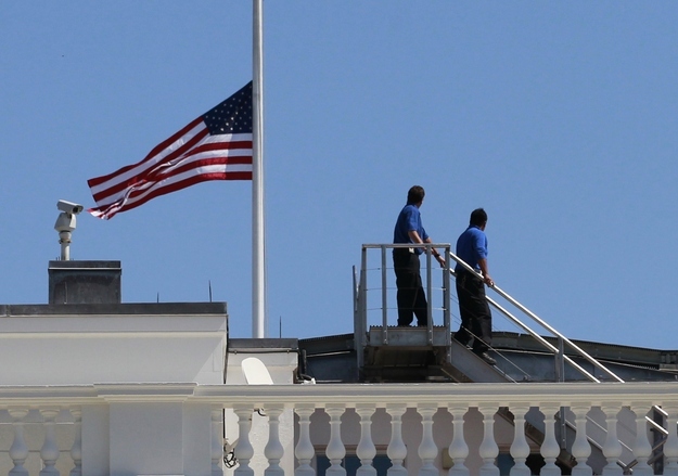September 12, 2012. White House staff are pictured after they lowered the U.S. flag to half staff on the roof of the White House.
