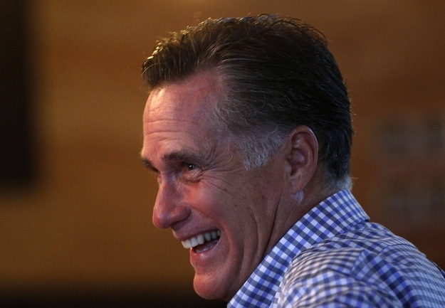 U.S. Republican presidential nominee and former Massachusetts Governor Mitt Romney laughs as he sits down to dinner at a restaurant in Delray Beach, Florida, October 21, 2012.
