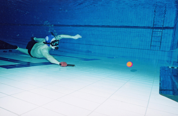 Octopush is simply underwater hockey, most commonly played at the bottom of large swimming pools. Instead of hockey sticks, players push the weighted puck around with small handheld sticks.