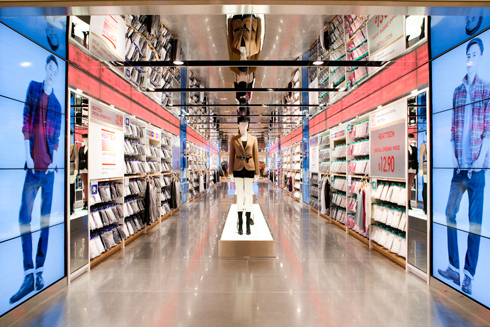 This Uniqlo flagship Fifth Avenue location features a 50,000-square-foot sales floor, four glass elevators, and three 60-foot escalators, surrounded by a staircase backlit with LEDs.