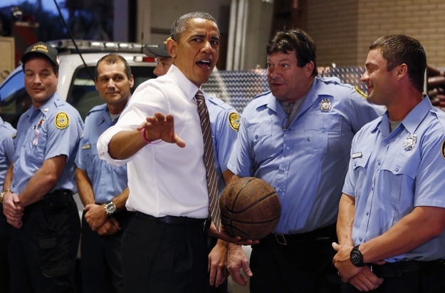 U.S. President Barack Obama reacts after a fire fighter offered up a game of basketball during a visit to a fire house in Tampa, Florida October 25, 2012.