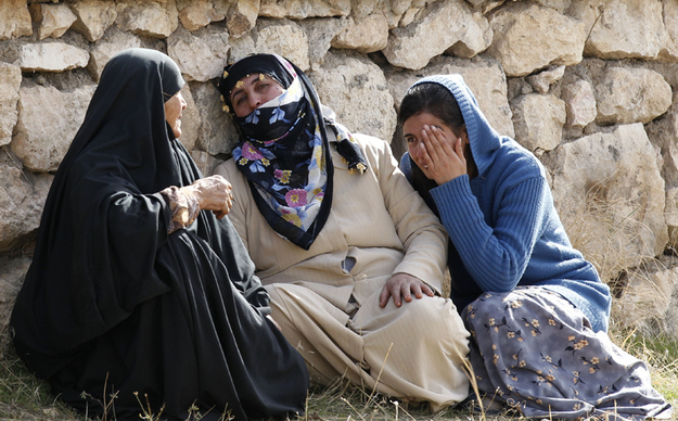 Women mourn at a cemetery for their relatives, killed during the earthquake, in Ercis.