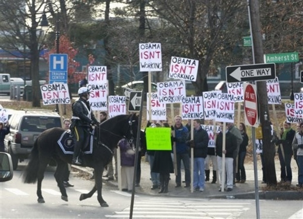 Protesters gather outside Manchester High School Central in Manchester, N.H., Tuesday, Nov. 22, 2011, as President Barack Obama motorcade arrived.