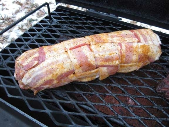 Cover snugly with the bacon quilt, add more rub, hit the grill. Cook under a fog of hickory smoke at 225 degrees until internal temperature reads 165. Baste with BBQ sauce towards end of grilling.