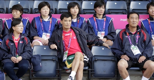 North Korea's coach Gun Sin Ui (2L, front) waits for his team's delayed group G women's match against Colombia to start in the football competition in the London 2012 Olympic Games at Hampden Park, Glasgow, Scotland, on July 25, 2012.