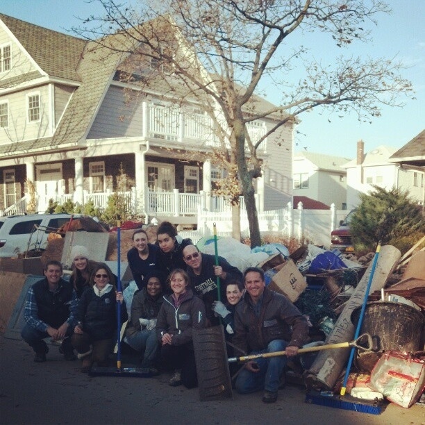 11 volunteers take a break after clearing a basement and a garage in Far Rockaway.