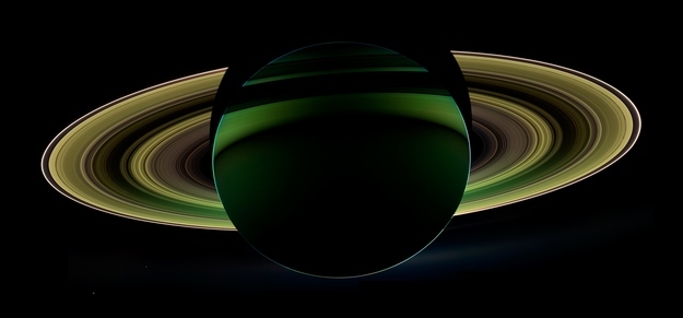 The Cassini spacecraft took this mosaic of the planet Saturn and its rings backlit against the Sun on October 17, 2012 using infrared, red and violet spectral filters that were combined to create an enhanced-color view, in this handout image courtesy of NASA. The images were obtained with the Cassini spacecraft wide-angle camera at a distance of approximately 500,000 miles (800,000 kilometers) from Saturn. Also captured are two of Saturn's moons: Enceladus and Tethys. Both appear on the left side of the planet, below the rings. Enceladus is closer to the rings; Tethys is below and to the left.