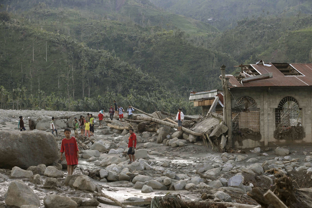Residents look at the devastation left from a flash flood at the height of Typhoon Bopha at the village of Andap, New Bataan township, Compostela Valley in southern Philippines, Dec. 5, 2012.