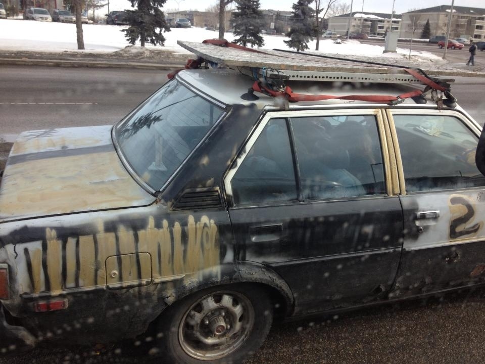 These hobos appear to be headed to renovate something, judging by the grade A particle board on the roof. One of them is passed out, probably from the fumes gusting out of the engine.