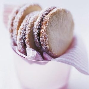 Save a little room to nibble on a plate of decadent alfajores. The secret to these tender and crumbly butter cookies is cornstarch in the dough. Sandwich them with dulce de leche and roll the edges in coconut for a final flourish!