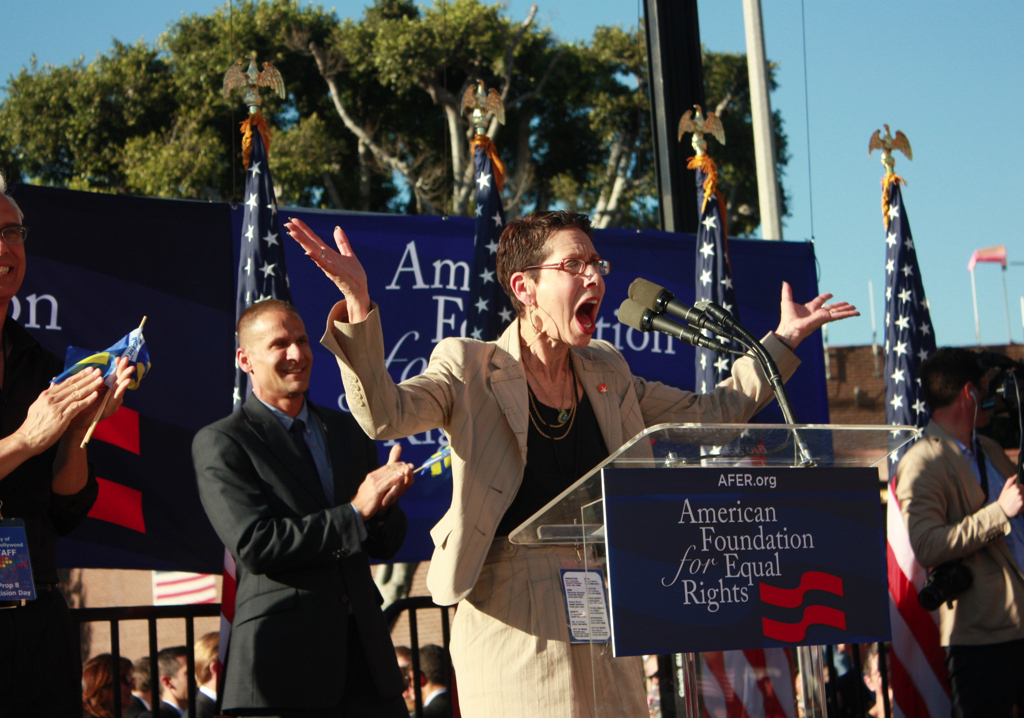 Abbe Land, a West Hollywood Councilmember and former mayor, was greeted by roaring applause. West Hollywood was the first city in the country to pass a resolution against the Defense of Marriage Act. In 1985, West Hollywood was the first city to create a same-gender domestic partnership registration for its residents, as well as to offer same-gender domestic partner benefits for city employees.