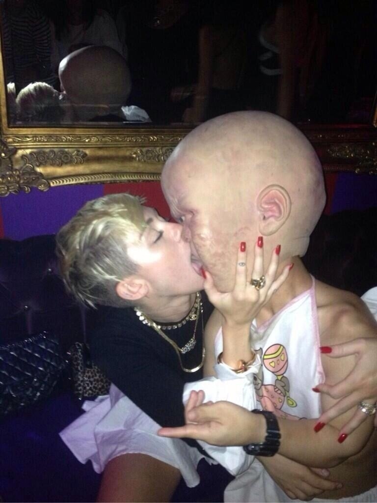 A photo of what appears to be Miley Cyrus tonguing a giant infant, posted by Reddit user PaisleyPowerRanger. I'm seeing a trend forming: