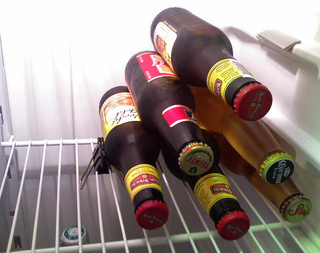 A binder clip keeps beverages neatly stacked in a tiny mini-fridge.