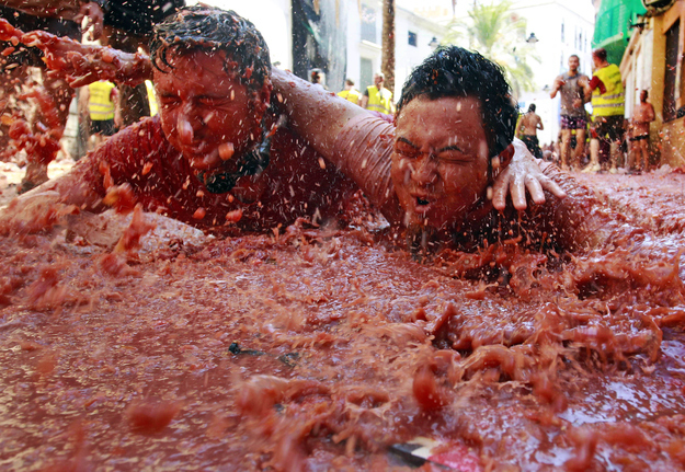 Hundreds of people lined the streets and threw tomatoes at each other and played in tomato pulp in the annual La Tomatina festival in Buñol, proving that fun still grows on trees, even after the iPad.
