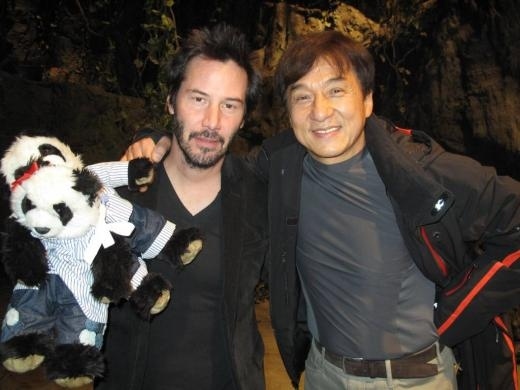Keanu Reeves and Jackie Chan with two pandas.
