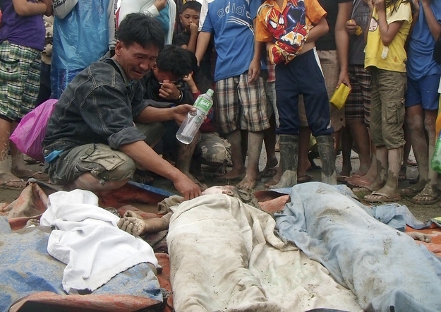 A father cries after finding his son among victims of a flash flood after Typhoon Bopha hit New Bataan, Compostela province, southern Philippines, Dec. 5, 2012. The death toll from the Philippines' strongest typhoon this year rose to around 230, with hundreds missing, local government officials said on Wednesday.
