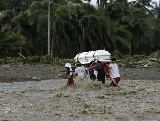 Relatives cross a river to bury their loved one, who died in a flash flood caused by Typhoon Bopha, Dec. 6, 2012, in New Bataan township, Compostela Valley in southern Philippines.