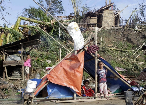 Children look out from a makeshift tent in Compostela Valley in southern Philippines, Dec. 6, 2012.