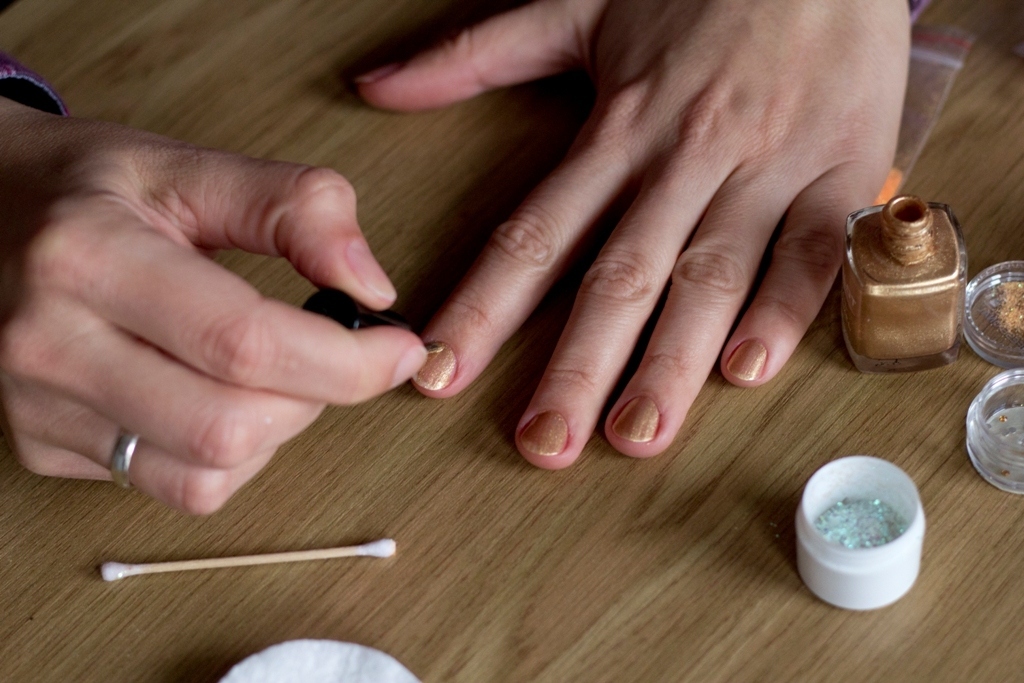 While the nail polish is still wet, use tweezesr to cover the nail with a piece of lace. Cover about half of the nail, and cut away any excess lace.