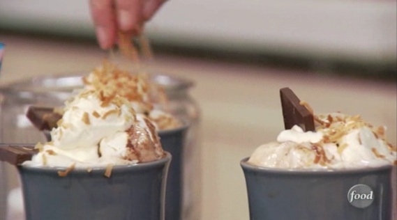 Ingredients8 cups milk6 ounces dark chocolate6 ounces white chocolate1/4 cup brown sugar1/4 cup granulated sugarMarshmallows, for toppingWhipped cream, for toppingToasted coconut, for toppingDirectionsIn a large saucepan, add the milk and 3 ounces of the dark and white chocolates. Turn onto medium heat and stir constantly. When the chocolate begins to melt, add the remaining chocolate and the sugars, and continue constantly stirring with a wire whisk until the chocolate is completely melted.Pour the hot chocolate into coffee cup and top with marshmallows. Brulee with a blow torch. Top with whip cream and toasted coconut.See the recipe (and instructional video) at food Network