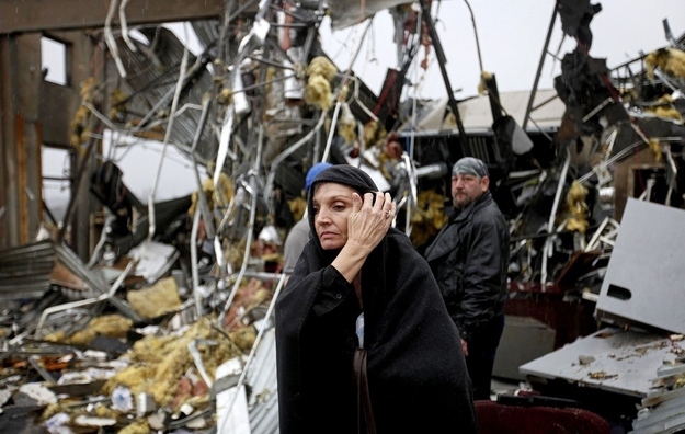 Pam Parker sifts through debris while looking for any personal belongings in the area where she was sitting at her desk when a tornado struck the Daiki plant, a metal fabrication company where she works in accounts payable.