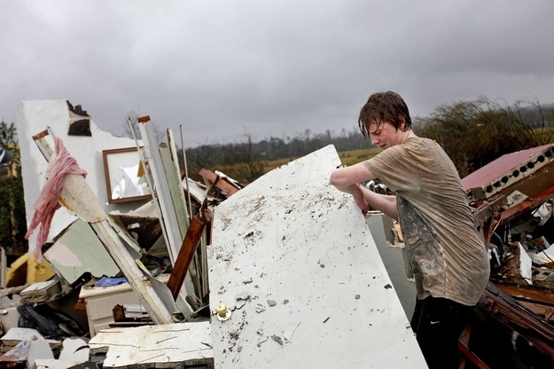 Will Carter, 15, pulls up debris while searching for the family dog, a pit bull named Niko.
