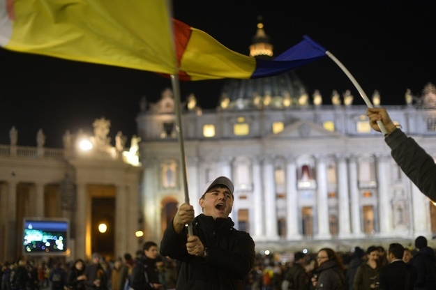 Catholics wave flags at St. Peter's Basilica.