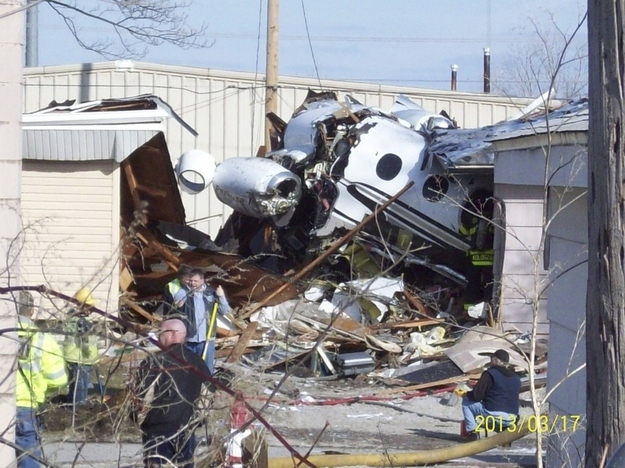 Firefighters and rescue workers look over the scene in South Bend, Indiana in this March 17, 2013 photo courtesy WNDU-TV after a small twin-jet aircraft crashed into houses near the South Bend Regional Airport.