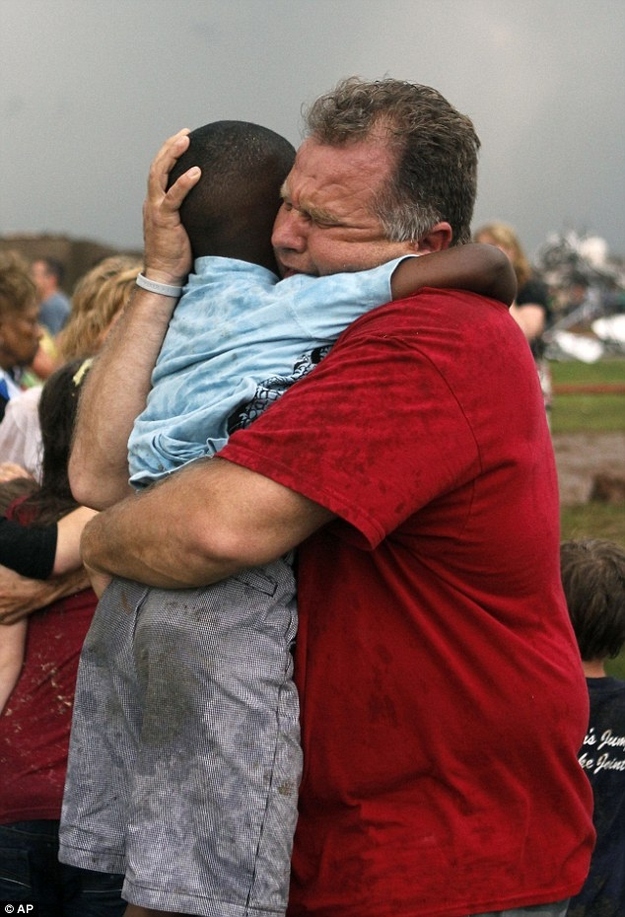 The hug seen 'round the world was initially thought to be a teacher embracing a student in the Briarwood Elementary aftermath, but it was later learned by CNN that the man and child were neighbors.The emotional man is Jim Routon and the 7-year-old boy is Hezekiah.The boy told CNN that he knew Routan was going to "pick me up, so I just jumped. And I just started hugging you really hard. I was crying a little bit, and I was happy that I survived."As for the picture becoming a face of the storm, Routon told CNN, "It actually helps us, you know, in the healing process -- and helps us to learn and see that ... we have to depend on one another to get through these types of things."