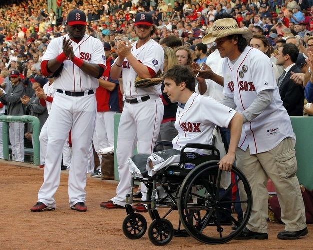 Red Sox's David Ortiz and Jarrod Saltalamacchia applaud as Boston Marathon survivor Jeff Bauman and Carlos Arredondo, who helped rescue Bauman, take the field to throw out ceremonial first pitches before the MLB interleague baseball game between the Philadelphia Phillies and the Boston Red Sox at Fenway Park.