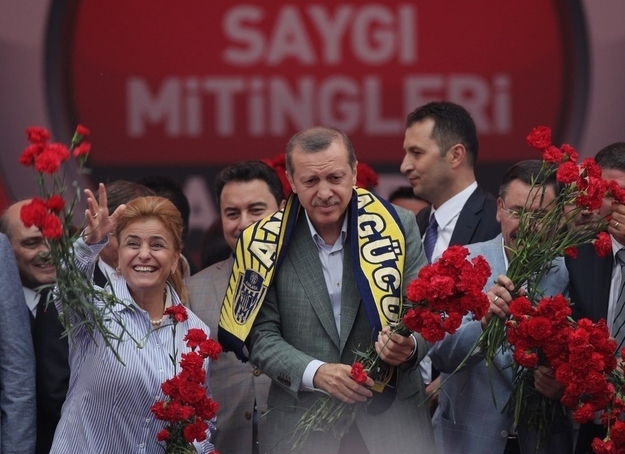 Prime Minister Erdogan and party members throw carnations toward supporters during a party rally outside Ankara.